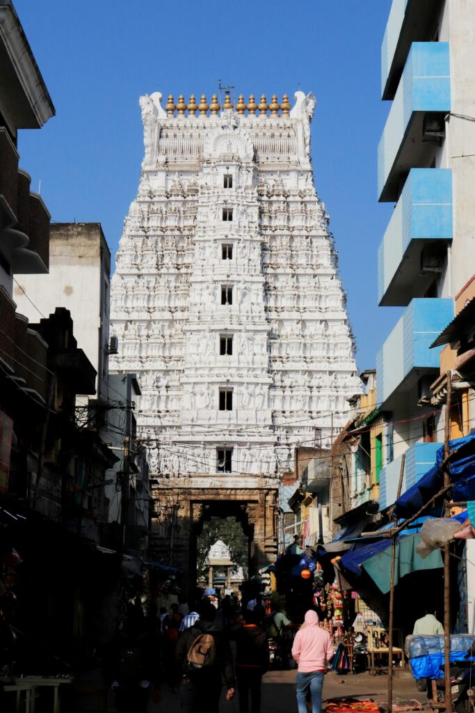 Govindaraja Swamy Temple amidst bustling street with tourists.