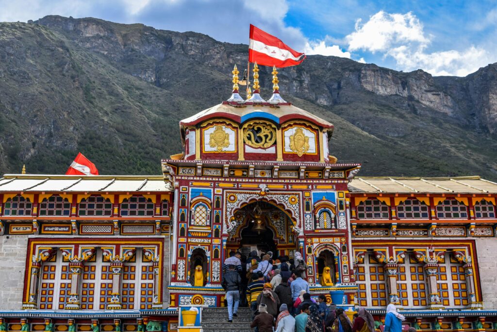 Vibrant view of Shree Badrinath Temple with pilgrims gathered around, set against a mountainous backdrop.